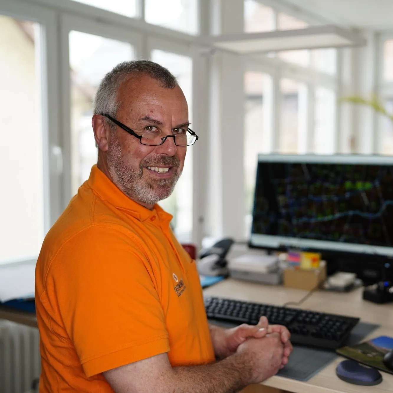 Mitarbeiter von SCHWINDT im orangefarbenen Poloshirt am CAD-Arbeitsplatz